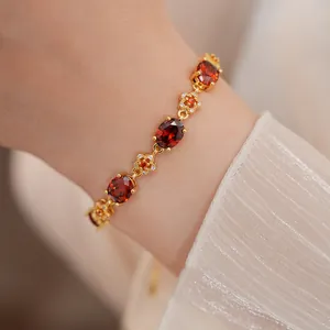 Κομψό επιχρυσωμένο βραχιόλι 18k με οβάλ κόκκινα ζιργκόν και λεπτεπίλεπτα λουλούδια