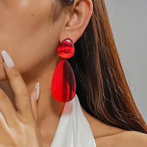 Close-up view of vibrant red resin water drop earrings showing detailed marble pattern