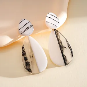 Elegant black and white marbled resin teardrop earrings with a chic minimalist design