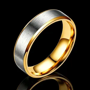 Détail en gros plan d'une bague en acier titane bicolore avec argent brossé et or