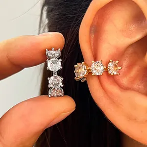 Close-up of elegant gold and silver zirconia ear cuffs with minimalist geometric design