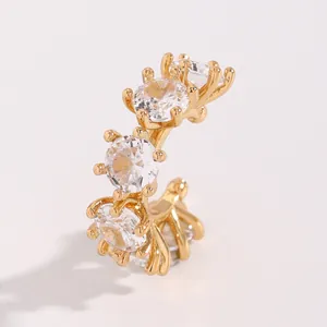 Detailed macro view of an elegant gold-plated ear cuff set with five sparkling zircons.