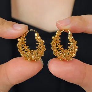 Vue détaillée des boucles d'oreilles rétro en forme de panier doré montrant la texture.