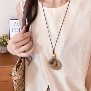 Close-up detail of retro ethnic necklace with resin and raffia woven pendant.