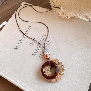 Detail view of ethnic necklace with raffia woven ring and resin pendant