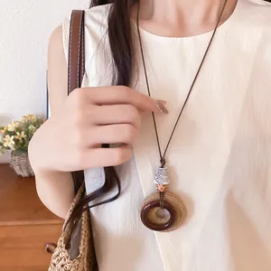 Detail shot of an ethnic style necklace featuring resin and raffia woven circles.