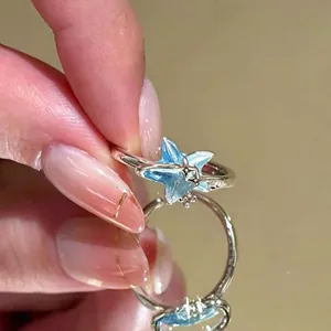 Detailweergave van een blauwe emaille sterring met zirkoonstenen op een handmodel