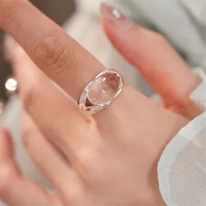 Vista ravvicinata di un elegante anello aperto in vetro ovale con un design in argento