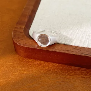 Vista macro dettagliata di un anello aperto in argento con perla in vetro ovale.