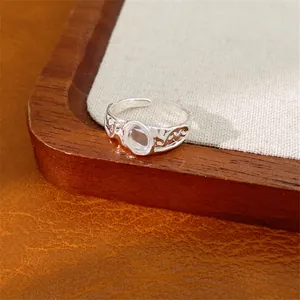 Primo piano di un anello regolabile in argento con vetro ovale trasparente e fascia martellata