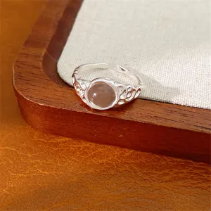 Primo piano di un anello regolabile minimalista in argento con una pietra di vetro traslucida