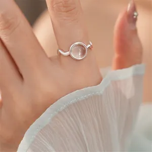 Primo piano di anello d'argento con pietra ovale in vetro trasparente