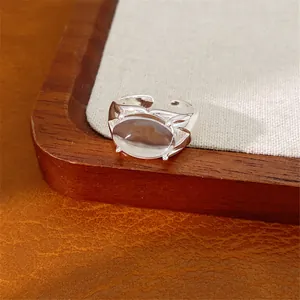 Dettaglio macro di anello d'argento minimalista con pietra di vetro ovale traslucida