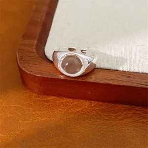 Primo piano di un anello regolabile in argento minimalista con pietra di vetro ovale