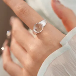 Dettaglio ravvicinato di un anello aperto in argento con pietra di vetro rotonda
