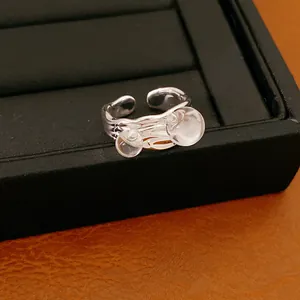 Primo piano di un anello aperto minimalista color argento con due bolle di vetro