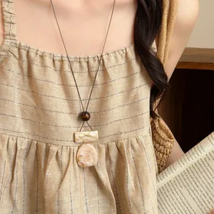 Retro marbled resin pendant necklace on model with vintage aesthetic props scene
