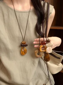 Close-up detail showing various vintage resin pendants on adjustable long cord necklaces