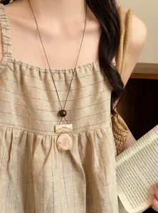 Detailed view of a vintage long necklace with marbled resin pendant on a model