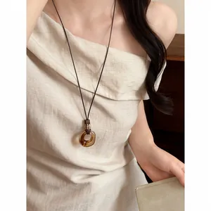 Detailed shot of a retro New Chinese style marbled ring pendant long necklace on a model
