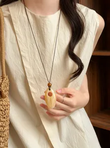 Detail view of a neo-Chinese retro marble-textured long pendant necklace on a model.