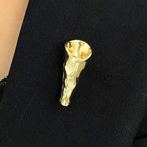 Detaillierte Makroansicht einer kreativen goldenen Brosche in Straußform auf Stoff