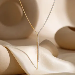 Detalle de un collar en forma de Y bañado en oro con una línea de strass brillantes