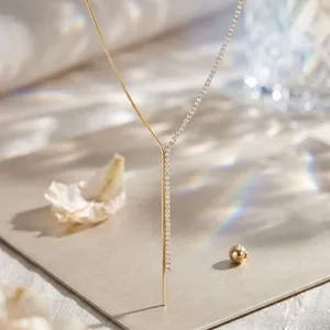 Primer plano detallado del collar en Y bañado en oro con elegante detalle de pedrería