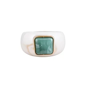 Bracciale rigido in acrilico crema con pietra marmorizzata verde e cornice dorata