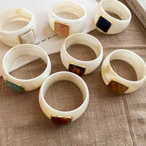 Assortimento di bracciali rigidi larghi in acrilico con pietre colorate e dorate