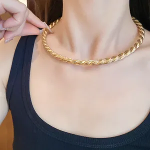 Detailed close-up of a vintage-style gold twisted rope choker necklace on a model's neck.