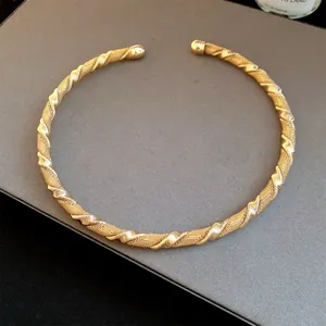 Detailed view of a vintage gold twisted mesh metal collar necklace with open design