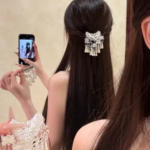 Gros plan d'une pince à cheveux vintage en argent avec pompons de style ethnique chic