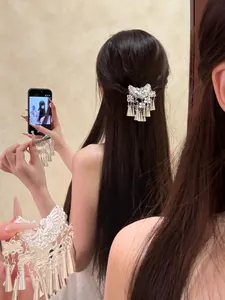 Détail macro d'une pince à cheveux ethnique argentée à pompons de style rétro Miao