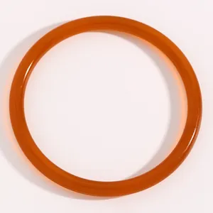 Primer plano detallado del brazalete de resina translúcida color caramelo con textura suave