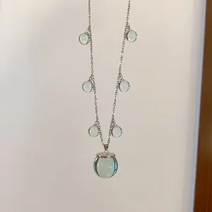 Primer plano de un collar de estilo coreano con esferas de resina verde translúcida.