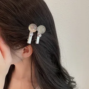 Detalle de primer plano de pinzas para el cabello de resina coreana en cabello oscuro