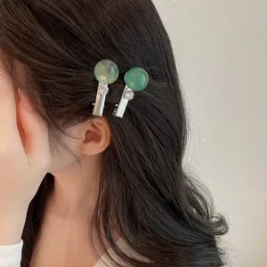 Vista detallada de dos pinzas para el cabello de resina verde transparente en el pelo