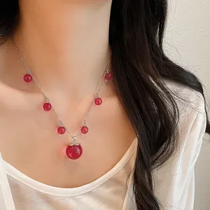 Elegante primer plano de un collar de cuentas de resina roja translúcida en una modelo