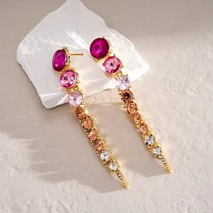 Detailed view of long gradient crystal dangle earrings with magenta and amber stones