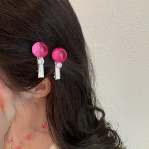 Detalle de pasadores de resina rosa y collar de cuentas a juego en una modelo asiática