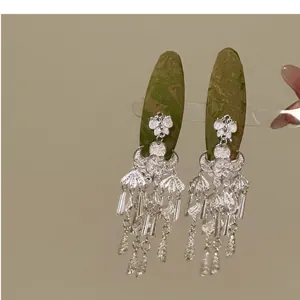 Detailed view of elegant silver Chinese style tassel hair clips with floral and bell motifs