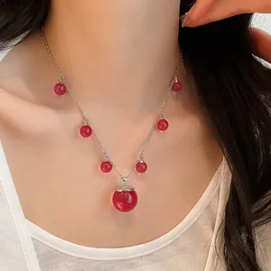 Vista detallada de un collar coreano con cuentas de resina roja translúcida