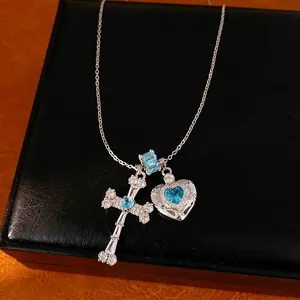 Elegant silver necklace with blue zircon heart and cross pendants on black box