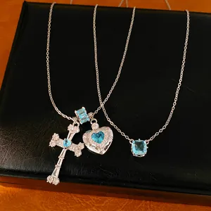 Detail view of silver necklaces with blue zircon cross, heart, and geometric pendants.