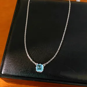 Close-up detail of light blue cushion-cut zircon pendant on silver chain jewelry box