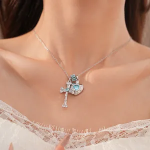Close-up detail showing the intricate blue zircon cross and heart pendants on a silver chain