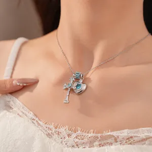 Detailed view of a silver necklace with blue zircon heart and cross pendants on a neck.