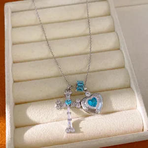 Detailed view of silver cross and blue heart zircon pendants on a luxury necklace