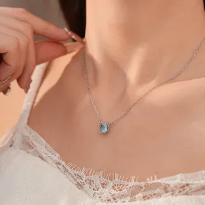 Detail view of elegant light blue square zircon pendant necklace worn on model's collarbone